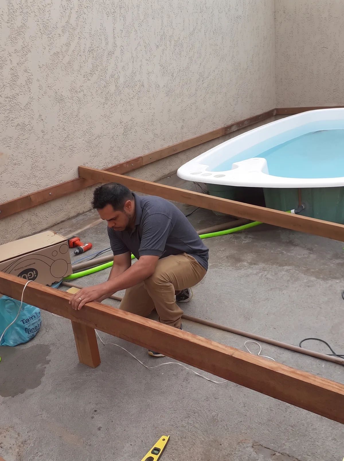 Luiz montando a estrutura de madeira do deck em volta da piscina